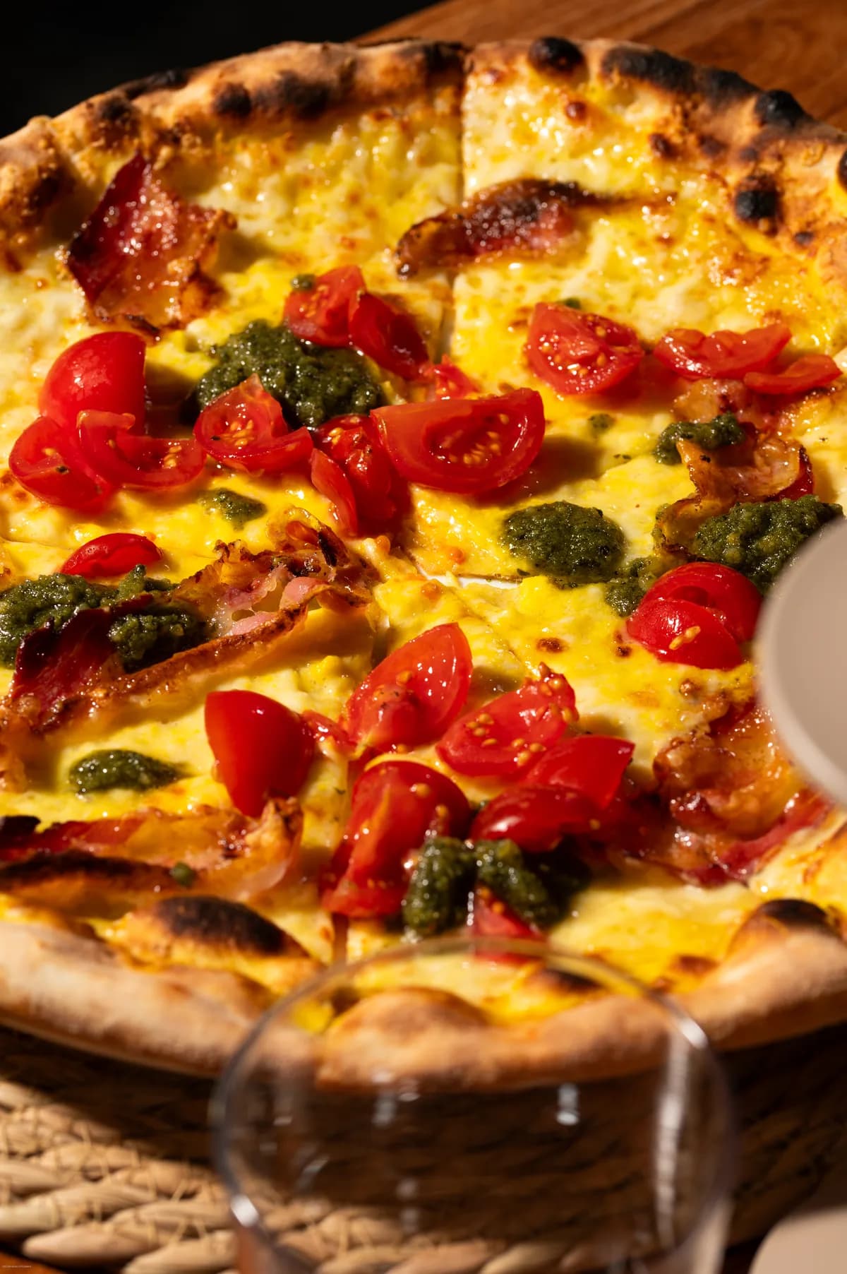 Pizza con pomodorini e pesto sul tavolo